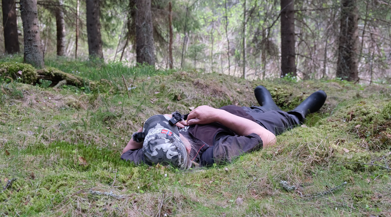 Elina Halonen liggende på skovbunden, mens hun lytter til naturen.